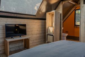 a bedroom with a bed and a tv on a wall at Glamping Pagliaini in Riparbella