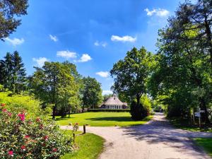 a path through a park with a building in the background at Forest Cabin in the woods in Holten