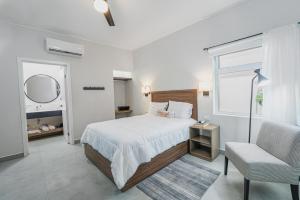 a bedroom with a bed and a chair and a window at Casa Othir in Monterrey