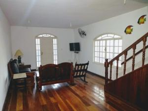 a living room with a staircase and two windows at Casa de temporada em Araruama in Araruama