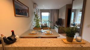 a kitchen and living room with a table and a living room at Flat das Montanhas in Rio de Janeiro