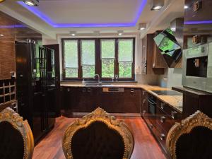 a kitchen with a sink and two chairs in it at PIOTROWSKi HOUSE in Ropica Górna