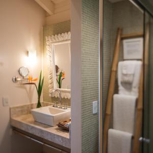 a bathroom with a sink and a mirror at Pousada Quinta do Bucanero in Imbituba +11 photos