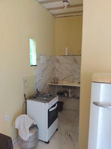 a kitchen with a stove top oven in a room at Recanto Jane e Daniel in Angra dos Reis