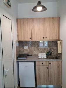 a kitchen with wooden cabinets and a white refrigerator at Matina Studios in Kefalos