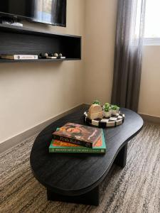 a black coffee table with books and plants on it at FIFA Monterrey Stay in Monterrey
