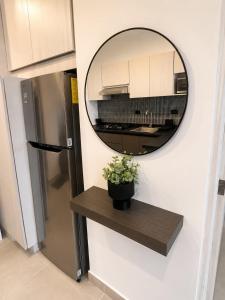 a mirror on a wall with a shelf and a refrigerator at FIFA Monterrey Stay in Monterrey +34 photos