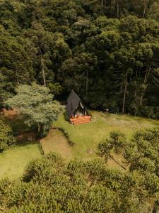 a small cabin in the middle of a field at Lumine Cabanas- Chalé na Serra Gaúcha in Farroupilha