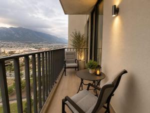 a balcony with a table and chairs and a view at Depto premium Valle Poniente UDEM Consulado 5px in Monterrey