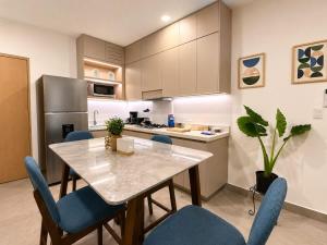 a kitchen with a table and chairs and a refrigerator at Depto premium Valle Poniente UDEM Consulado 5px in Monterrey
