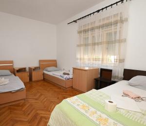 a room with three beds and a window at Hostel Holiday Cetinje in Cetinje +26 photos