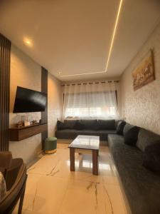 a living room with a couch and a table at Mehdia plage in Kenitra
