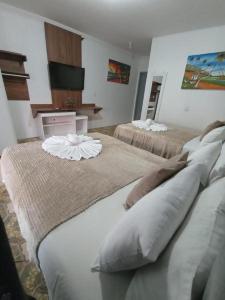 a bedroom with two beds with pillows on them at Pousada Maceió é Massa Beira Mar in Maceió