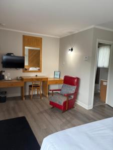 a room with a desk and a chair and a table at Le Délice Motel Restaurant in Mont-saint-pierre