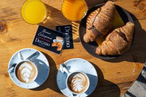 a table with two plates of coffee and croissants at Duomo Charming Rooms in Barletta