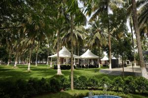 a group of tents in a park with palm trees at Winners Hill Resort Walayar by Arcadia in Coimbatore