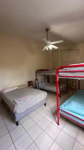 a room with two beds and a ceiling fan at Hostal Sam in Managua