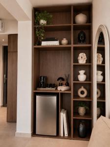a book shelf with a mirror in a living room at Kastri Beach Suites in Faliraki