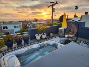 a bath tub sitting on top of a balcony with plants at Luxury Spa Townhome with Rooftop Ocean View Jacuzzi in Hermosa Beach