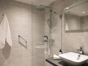 a bathroom with a glass shower and a sink at Mercure Amsterdam North Station in Amsterdam +60 photos