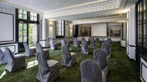 a conference room with chairs and a projection screen at Aigle Noir Hotel Fontainebleau - MGallery Collection in Fontainebleau