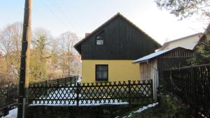 a yellow and black house with a black roof at Ferienwohnungen Rico Eglin in Struppen