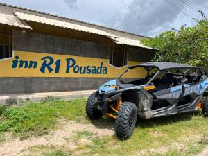 an atv parked in the grass in front of a building at Inn R1 Pousada e Passeios in Barreirinhas