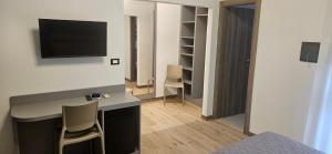 a bedroom with a desk with a television on a wall at Hotel Sole in Eraclea Mare