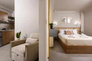 a small bedroom with a bed and a chair at Aeliana Thassos Studios & Lofts in Skala Rachoniou +44 photos