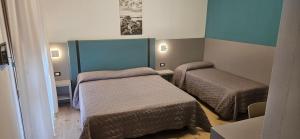 a small room with two beds in it at Hotel Sole in Eraclea Mare