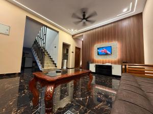 a living room with a couch and a ceiling fan at Vihaalaya stays in Tozhuppedu