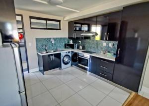 a kitchen with a washer and dryer in it at The Safari Launchpad Windhoek in Windhoek