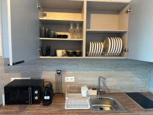 a kitchen with a sink and a counter with chairs at Kyma Sunset Suite w Prvate Jacuzzi in Paros National Airport +17 photos