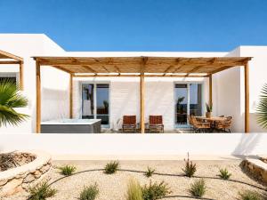 two views of a home with a patio and dining area at Kyma Sunset Suite w Prvate Jacuzzi in Paros National Airport