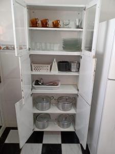 an open white refrigerator with pots and pans at Casa de temporada em Araruama in Araruama