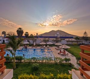 a view of the pool at a resort with a mountain in the background at Hotel La Colina in Ica
