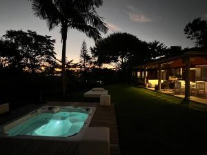 a jacuzzi tub in a yard with a house at Pousada Quinta do Bucanero in Imbituba