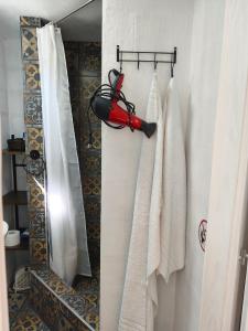 a bathroom with white towels and a red umbrella at Guest house with sauna in Krčedin