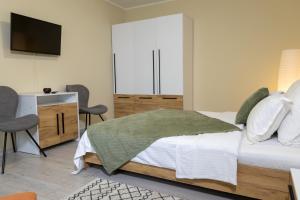 a bedroom with a bed and a flat screen tv at Casa SEMA in Sinaia