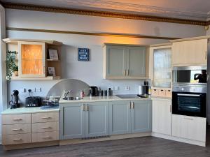 a large kitchen with white cabinets and appliances at Longsands Beach, Apartment 2, Tynemouth in Tynemouth
