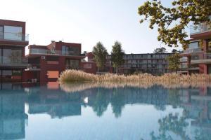 a reflection of buildings in a body of water at Gemini Superior Apartman & Yacht in Balatonlelle