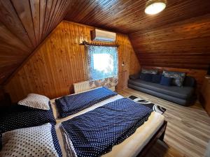 a bedroom with a bed and a couch in a room at Éva Vendégház in Hajdúnánás