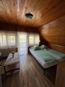 a bedroom with a bed and a wooden ceiling at Éva Vendégház in Hajdúnánás +5 photos
