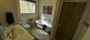 a bathroom with a tub and a toilet and a sink at Sand And Sea Self Catering #3 in Swakopmund +26 photos