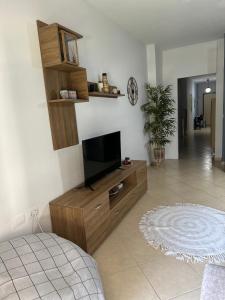 a living room with a flat screen tv on a wooden entertainment center at Gjonis house in Sarandë