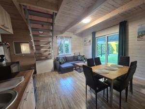 a kitchen and living room with a table and chairs at Domki na Polnej in Grzybowo