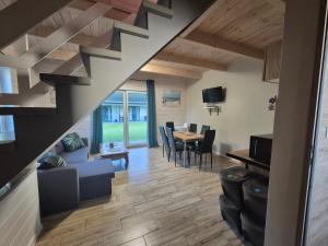 a living room and dining room with a staircase at Domki na Polnej in Grzybowo