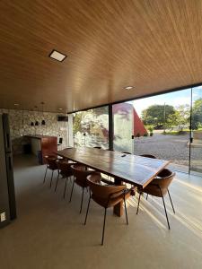 a dining room with a large wooden table and chairs at Chalé A-Frame em Garanhuns - PE/ Rota do Frio in Garanhuns