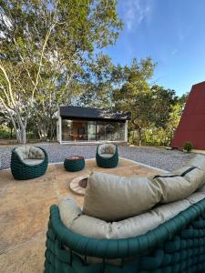 a large couch sitting on a patio with trees at Chalé A-Frame em Garanhuns - PE/ Rota do Frio in Garanhuns