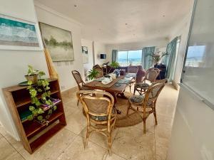 a dining room with a table and chairs at Skye Beach Villa in Tergniet